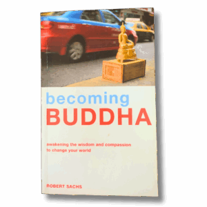 Cover of “Becoming Buddha” by Robert Sachs showing a small golden Buddha statue on a wooden crate beside a busy city street with blurred cars in the background.