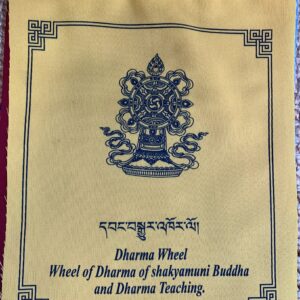 A yellow prayer flag with the text 'WHEEL OF DHARMA' and a graphic symbol in the center, indicating the theme of Shakyamuni Buddha and Dharma Teaching.