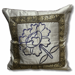 Handcrafted decorative cushion in soft grey fabric featuring an embroidered floral design in blue and cream, framed with ornate gold brocade trim.
