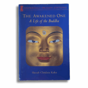 Cover of “The Awakened One: A Life of the Buddha” by Sherab Chödzin Kohn, featuring a close-up golden Buddha face with blue background and Shambhala Dragon Editions branding.