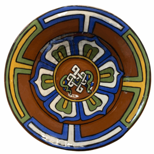 A ceramic bowl with geometric patterns and a central lotus design, featuring a combination of blue, brown, green, and white colors.