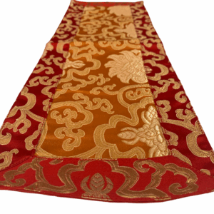 A small rectangular brocade altar cloth with floral patterns in gold and red colors, handmade in Nepal.