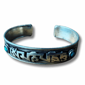 Handcrafted Tibetan silver-tone metal cuff bracelet engraved with the Om Mani Padme Hum mantra and set with turquoise stones at each end.