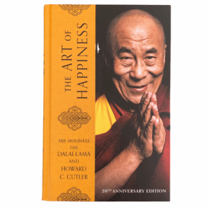 The cover of the book 'The Art of Happiness - A Handbook for Living' by His Holiness the Dalai Lama and Howard C. Cutler features a portrait of the Dalai Lama in a yellow and red traditional outfit, smiling.
