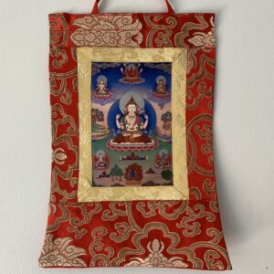 A mini Brocade Thangka depicting the bodhisattva Chenrezig, with intricate red and gold patterns surrounding the figure.