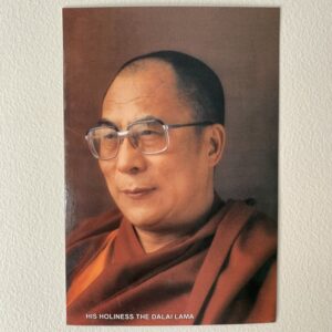Postcard-sized image of His Holiness the 14th Dalai Lama wearing glasses and a red monk's outfit.