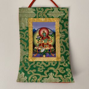 A mini brocade thangka featuring the green tara, with a vibrant multicolored backdrop and a central figure depicted in a yellow and red frame.