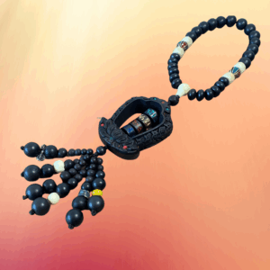 A rose wood amulet with a turning compassion mantra engraved in Chinese script, decorated with white and embellished beads, and mini vajra charms.