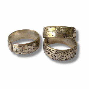 Three engraved metal rings, one with a more detailed dragon design than the other, on a white background.
