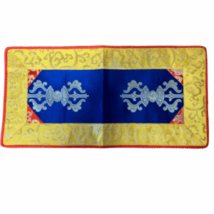 A brocade placemat featuring a yellow surface with red and blue floral brocade patterns and a red or yellow trim.