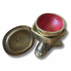 Traditional Tibetan kapala skull cup with brass lid and vajra finial, used as a ritual offering vessel in Buddhist practice.