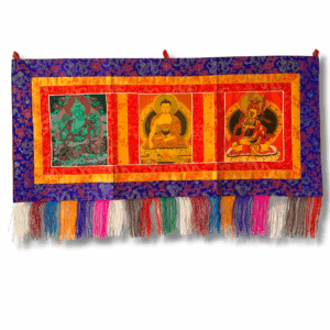 Three Deity Tibetan wall hanging with colourful silk brocade border, three printed deity panels, and multicoloured fringe tassels along the bottom.
