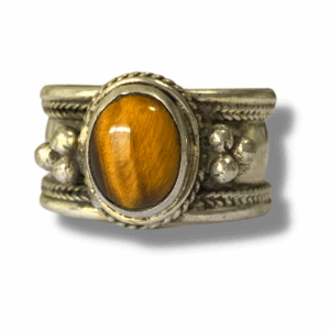 Tibetan-style silver cuff ring featuring an oval golden tiger’s eye stone set in an ornate white-metal band with braided and beaded detailing.