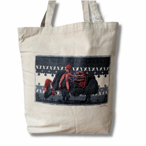 A beige tote bag with a central Tibetan cultural art design featuring a black yak, surrounded by decorative elements.